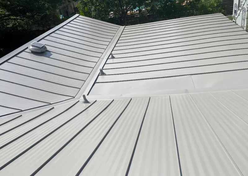 Solar attic fan installed on a metal roof for Roof Ventilation in Tichigan